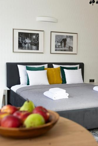 two beds in a room with a bowl of fruit on a table at Balans Studio Old Town in Gdańsk