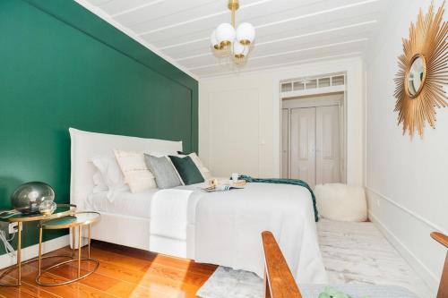 リスボンにあるStunning & modern 2 Bedroom Apartment in Chiadoの緑の壁のベッドルーム1室(白いベッド1台付)