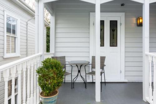 une terrasse couverte avec une table et des chaises sur une maison dans l'établissement Light-filled Renovated Villa Walk to Ponsonby Road, à Auckland