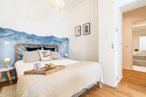 um quarto com uma cama grande e uma parede azul em Spacious Studio in Lisbon em Lisboa