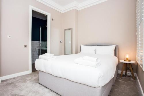 ロンドンにあるBright Vibrant 1 Bedroom Apartment in South Hampsteadの白いベッドルーム(大型ベッド1台、白い枕付)