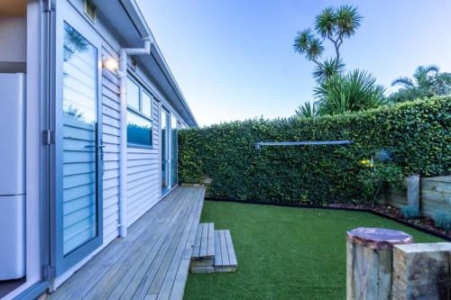 a backyard with a wooden porch with a lawn at Sunny Character 2 Bedroom Home - Mission Bay in Auckland