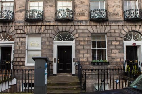 エディンバラにあるSophisticated Edinburgh Apartment in City Centreの黒い扉と窓のある石造りの建物