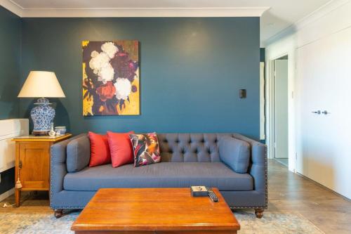 a living room with a blue couch and a table at Modern 1 Bedroom Apartment In The Italian Forum in Sydney