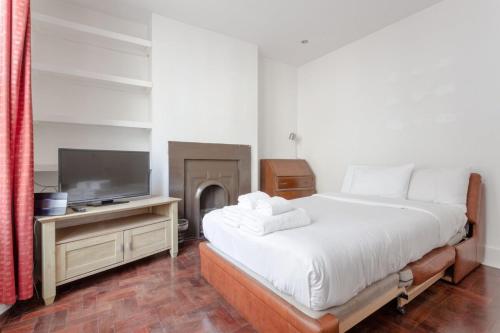 a bedroom with a large bed and a tv at Modern 2 Bedroom flat in Central London in London