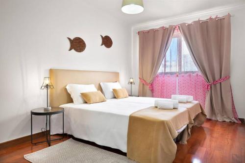 a bedroom with a large white bed and a window at BARRAMARES 5 - 4ºandar PISCINA EXTERIOR VISTA MAR in Ovar