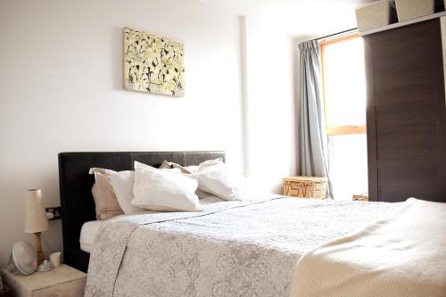 ロンドンにあるStylish River View Apartment in Zone 2のベッドルーム1室(白いシーツ付きのベッド1台、窓付)