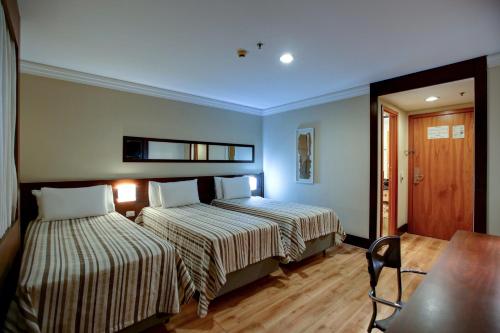 two beds in a room with blue ceilings at Transamerica Executive Congonhas in Sao Paulo