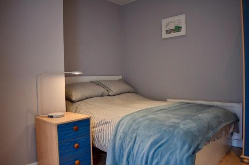 a small bedroom with a bed and a night stand at Charming 2 Bedroom Cottage in Central Location in Dublin