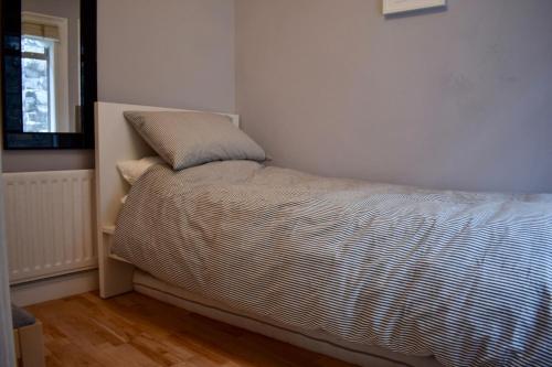 a bed in a corner of a bedroom at Charming 2 Bedroom Cottage in Central Location in Dublin