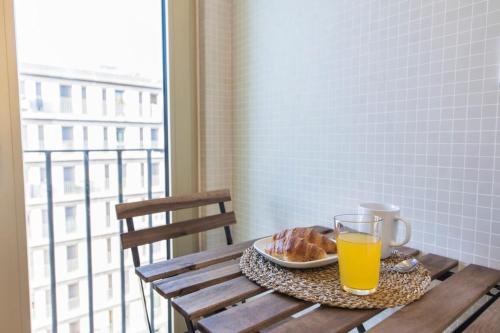 einen Tisch mit einem Glas Orangensaft und einem Teller Donuts in der Unterkunft Comfortable Apartment in Campo Pequeno in Lissabon