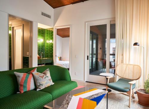 a living room with a green couch and a bedroom at Hotel Magdalena in Austin