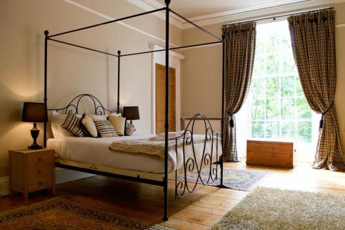 エディンバラにあるEnormous Luxury 4 Bedroom Apartmentのベッドルーム(天蓋付きベッド1台、大きな窓付)