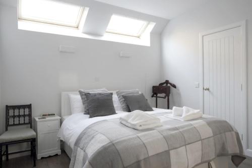 a white bedroom with a bed with two towels on it at Quiet Ground Floor Mews Flat and parking in Edinburgh