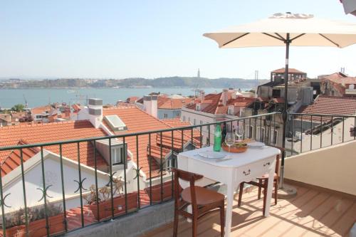 リスボンにあるBright 1 Bedroom top floor apartment with terrace & river viewのバルコニー(テーブル、傘付)