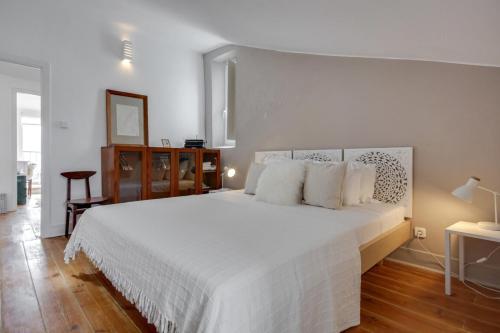 リスボンにあるBright 1 Bedroom top floor apartment with terrace & river viewのベッドルーム(白い大型ベッド、白い枕付)