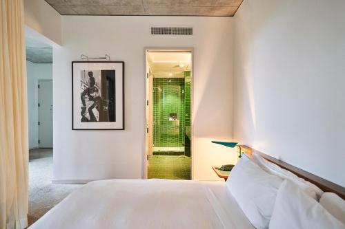 a bedroom with a bed and a shower at Hotel Magdalena in Austin