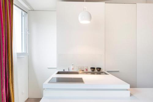 une cuisine avec des armoires blanches et un évier dans l'établissement Modern Apartment in the Heart of the Marais, à Paris