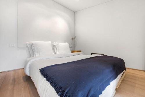 - une chambre avec un grand lit et une couverture bleue dans l'établissement Modern Apartment in the Heart of the Marais, à Paris