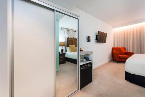 a room with a mirror and a bedroom with a bed at Bohemian 1 Bedroom Apartment with Rooftop Terrace in Perth