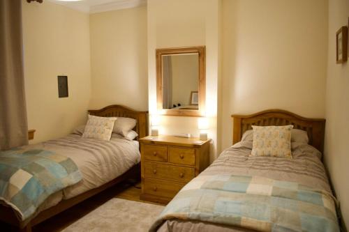 a bedroom with two beds and a mirror at Newly Refurbed Home with Free Parking in Edinburgh