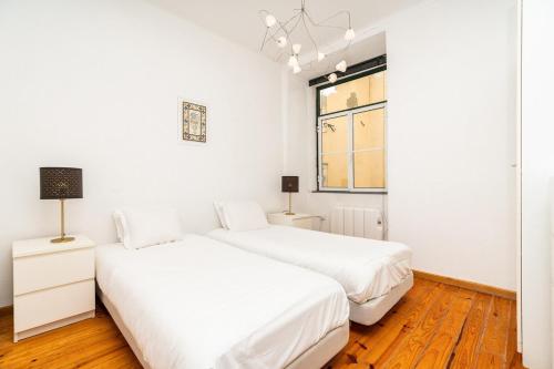 A bed or beds in a room at Charming 2 Bedroom Apartment next to Praça da figueira