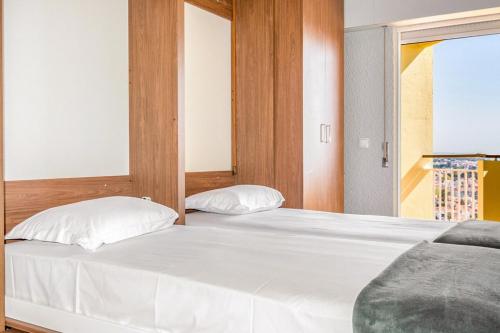 um quarto com uma grande cama branca e uma janela em Wonderful Studio in Cascais with Sea View em Cascais