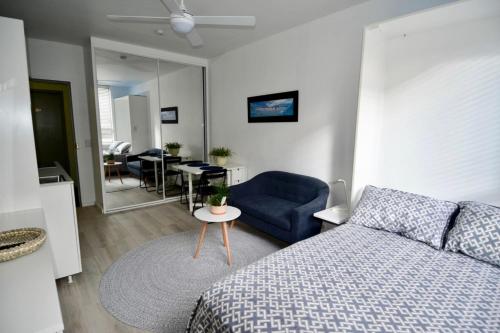 a bedroom with a bed and a blue couch and a table at Cute Studio Apartment in Maroubra in Sydney