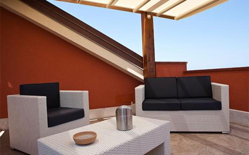 a patio with two chairs and a table at B&B 7Cento Ulivi in Valderice