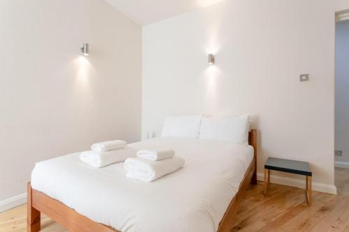 a white bed with towels on top of it at Fantastic 2 Bedroom Apartment in Central London in London