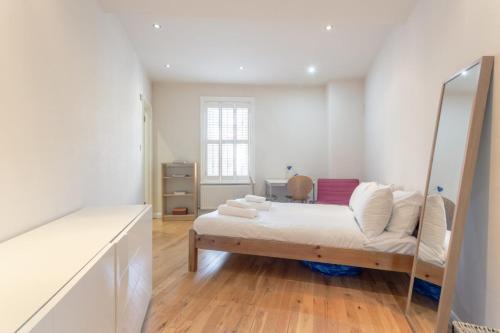 a white room with a bed and a mirror at Fantastic 2 Bedroom Apartment in Central London in London