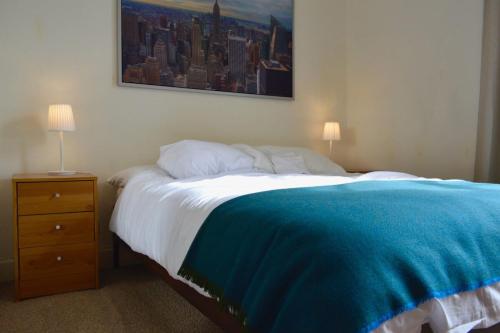 a bedroom with a bed with a blue blanket on it at Sophisticated and Bright One Bed in Leith in Edinburgh
