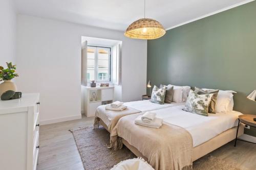 1 Schlafzimmer mit 2 Betten und einem Kronleuchter in der Unterkunft Stunning 2 Bedroom Apartment near Belém in Lissabon