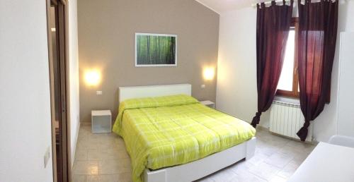 um quarto com uma cama com um cobertor amarelo em B&B Hibiscus em Capoterra