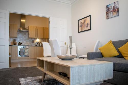 エディンバラにあるBeautifully Renovated Apartment -Central Edinburghのリビングルーム(ソファ、テーブル付)