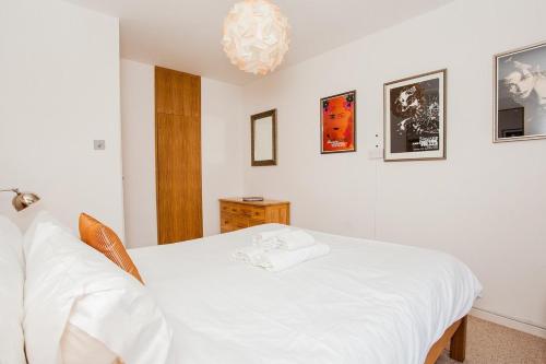 a bedroom with a white bed and a chandelier at Stylish 1 Bedroom Flat in Vauxhall in London