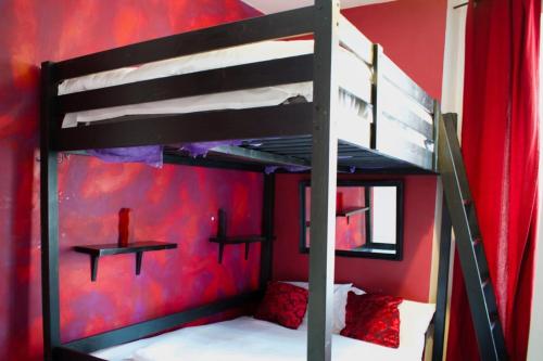エディンバラにあるCasa Fiore - Recently Renovated- Central and cosyの赤い壁のドミトリールームの二段ベッド1台分です。