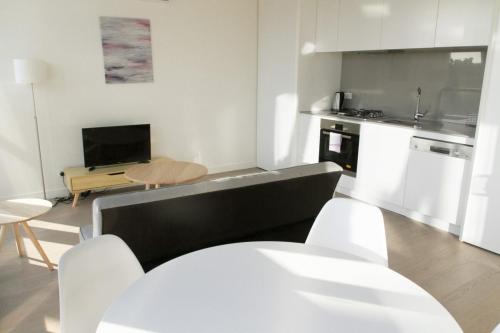 Il comprend un salon avec un canapé et une cuisine. dans l'établissement Modern Light-Filled Luxury 1Bedroom Apartment in South Melbourne, à Melbourne