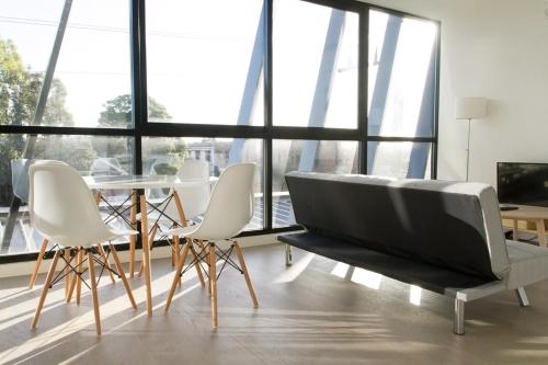 - un salon avec un canapé, des chaises et une table dans l'établissement Modern Light-Filled Luxury 1Bedroom Apartment in South Melbourne, à Melbourne