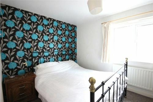 sypialnia z łóżkiem z czarno-niebieskim zagłówkiem w obiekcie Charming Cosy Coach House in Fishponds Bristol w Bristolu