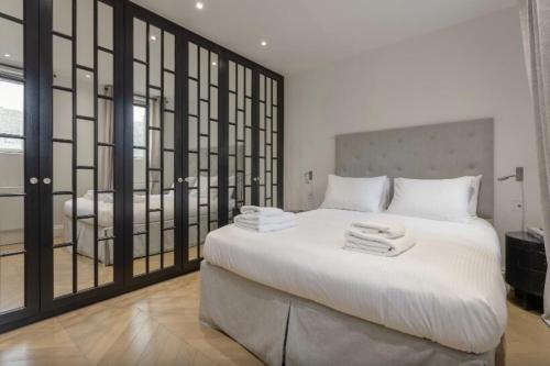 a bedroom with a large bed with towels on it at Elegant 1 Bedroom Apartment in South Kensington in London