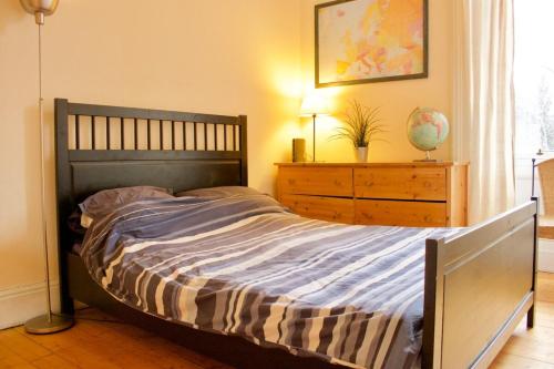 a bedroom with a large bed with a dresser and a window at Classic Edinburgh Flat in the heart of Morningside in Edinburgh