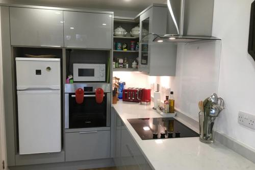 a kitchen with white cabinets and a white refrigerator at Bright Spacious 2 Bedroom Apartment in Stockbridge in Edinburgh