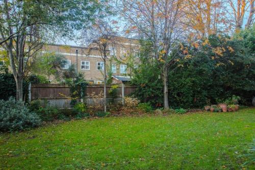 a house with a fence in a yard at Contemporary 1Bedroom Flat in Camberwell Oval in London