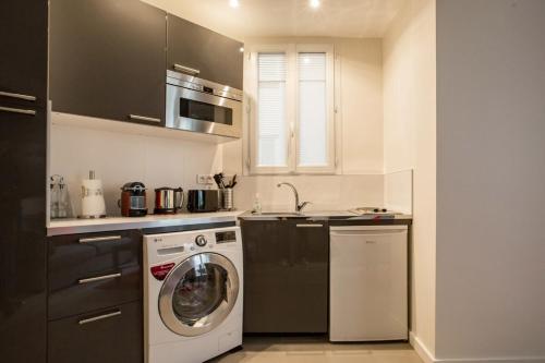 une cuisine avec un lave-linge et un lave-vaisselle dans l'établissement Modern arty flat close to Saint-Germain des Près, à Paris