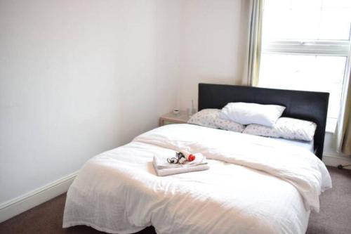 sypialnia z białym łóżkiem i oknem w obiekcie Lovely Victorian Flat for 6 in Stoke Newington w Londynie