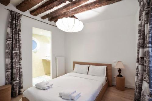 1 dormitorio con 1 cama con 2 toallas en Parisian Apartment With Terrace in Saint Michel-Notre Dame en París