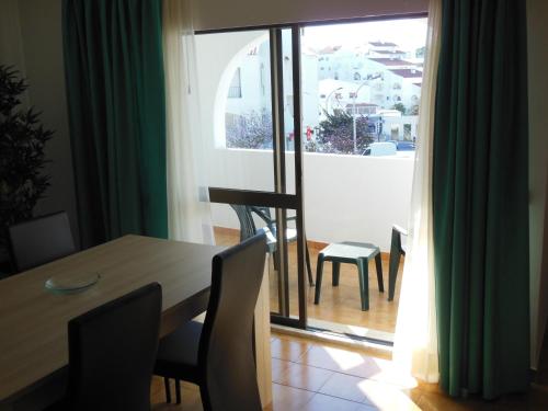 a dining room with a table and chairs and a window at Original Apartments in Albufeira