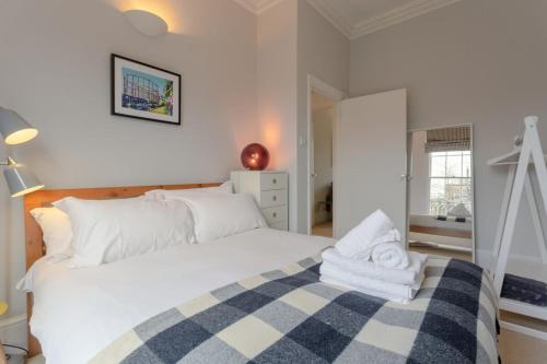Vibrant 1 Bedroom Flat In Islington With Garden في لندن: غرفة نوم بسرير ابيض كبير عليها مناشف
