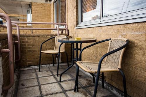 ロンドンにあるBeautiful Views - 1-Bedroom in Chancery Laneの椅子2脚、テーブル1台、テーブル2台、椅子2脚